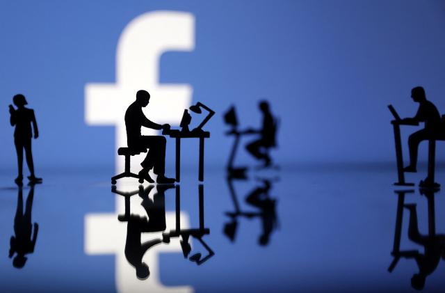 Figurines with computers and smartphones are seen in front of Facebook logo in this illustration, July 24, 2022. REUTERS/Dado Ruvic/Illustration