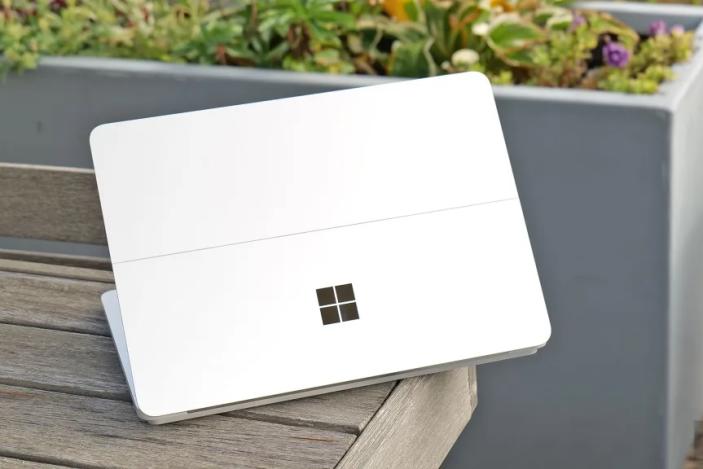 A white device with the Microsoft Windows logo on top of a wooden bench.