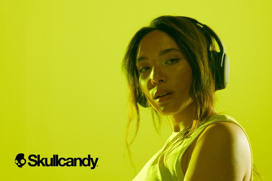 Skullcandy unveils the Crusher 2 ANC headphones with an image of a lady over a yellow background wearing the headphones. 