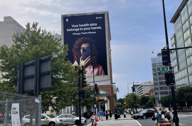 An Apple "Privacy. That's iPhone." ad on the side of a building in Washington, DC featuring a person holding an iPhone in front of their face.