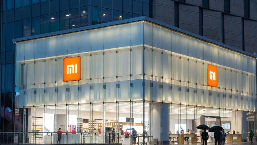 NanJing,JiangSu/China-November 06 2018：Customers experience xiaomi products in the xiaomi store and there are many people passing by in the square outside on a rainy night