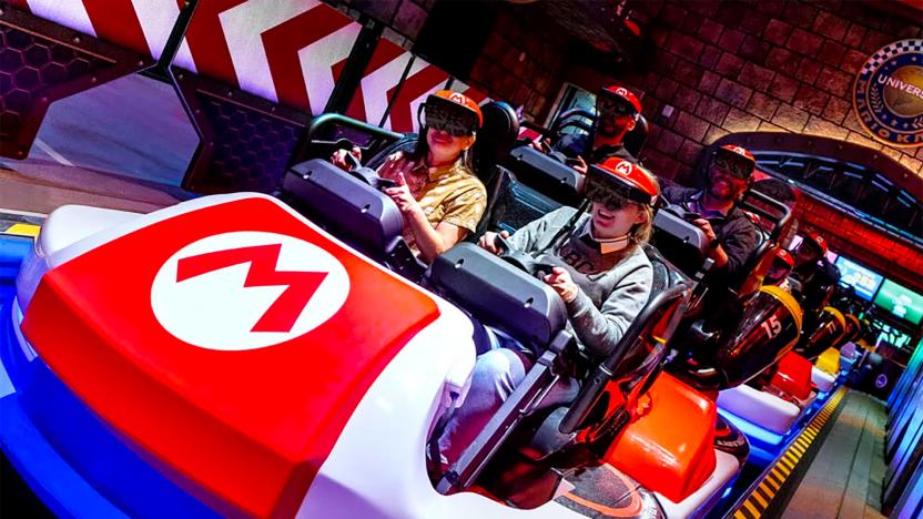 Smiling park visitors sit inside cars at the Universal Studios ‘Mario Kart’ ride. The car has a Mario ‘M’ logo on it.