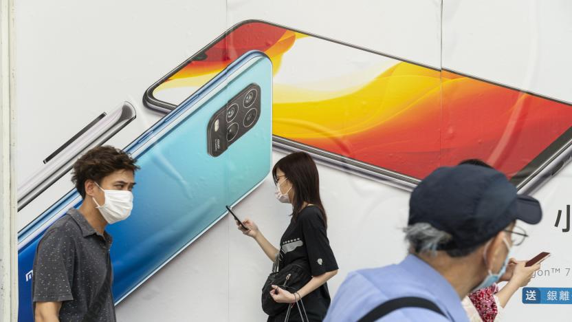 HONG KONG, CHINA - 2020/07/07: Commuters wearing face masks pass by a Xiaomi smartphone advertisement at its flagship store in Hong Kong. (Photo by Budrul Chukrut/SOPA Images/LightRocket via Getty Images)