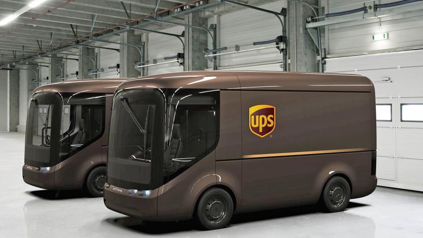 Two UPS concept delivery vans from auto maker Arrival are parked in the empty end of a warehouse / loading dock facility.