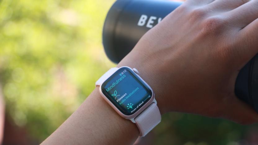 The Apple Watch Series 9 on a person's wrist, with the hand holding a black water bottle in the background. The screen shows the Mindfulness app.