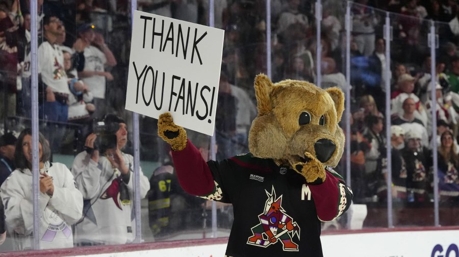 Associated Press - Arizona Coyotes mascot Howler acknowledges holds a sign after the team's NHL hockey game against the Edmonton Oilers on Wednesday, April 17, 2024, in Tempe, Ariz. The Coyotes won 5-2. Team owner Alex Meruelo agreed to sell franchise's hockey operations to Utah Jazz owner Ryan Smith, who intends to move the team to Salt Lake City. (AP Photo/Ross D. Franklin)