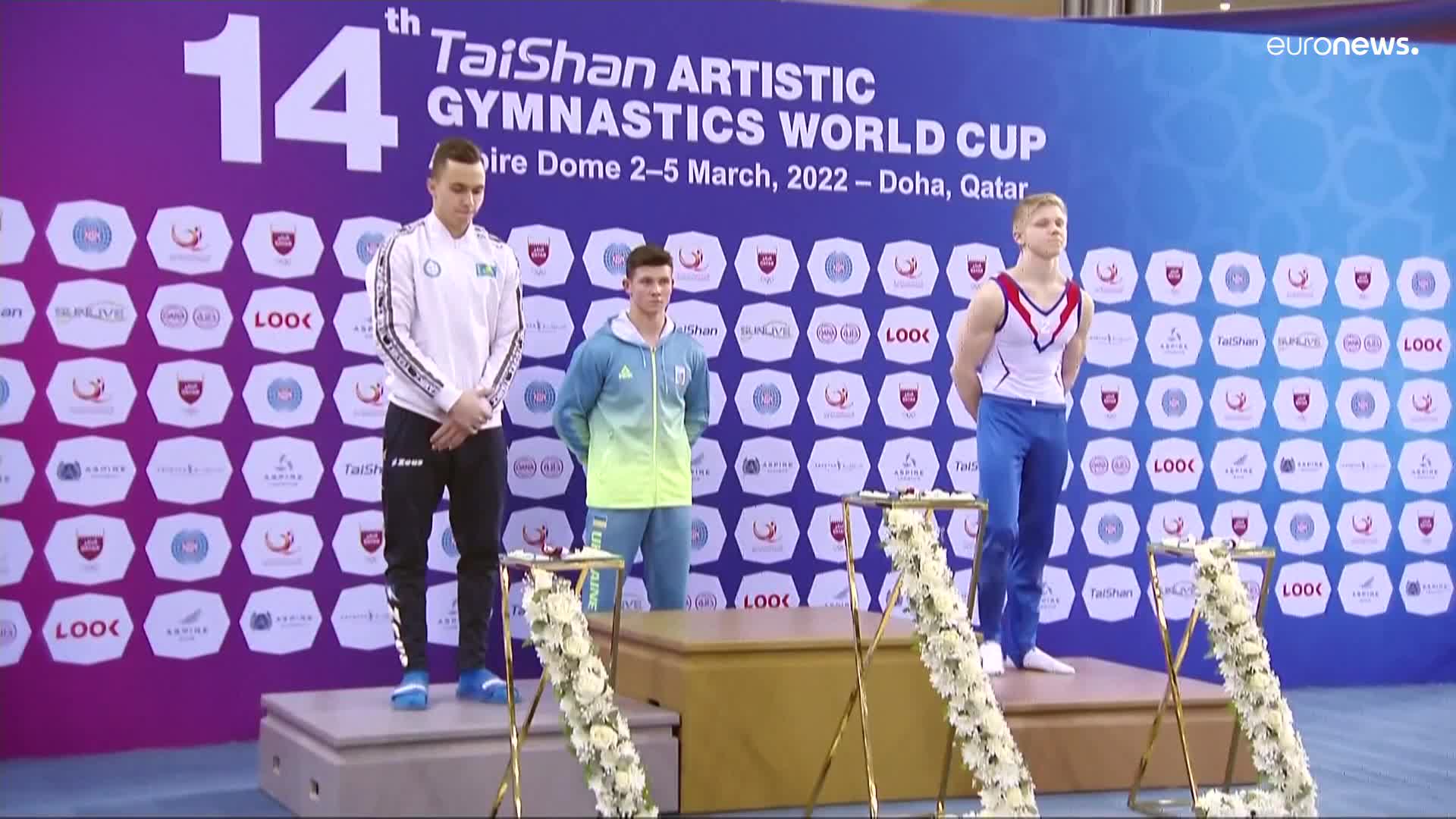 Russian gymnast stands on the podium with symbol supporting