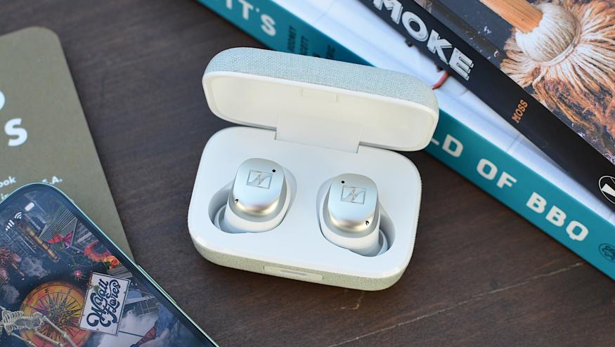 White/silver Sennheiser Momentum True Wireless 4 earbuds sitting in their case with the lid open.