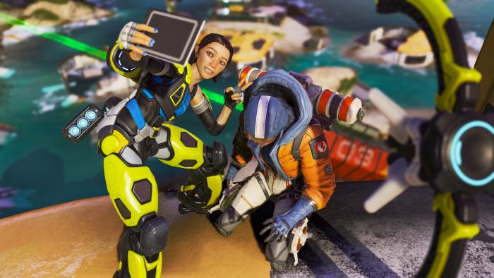 Apex Legends character Conduit takes a selfie with a downed opponent.