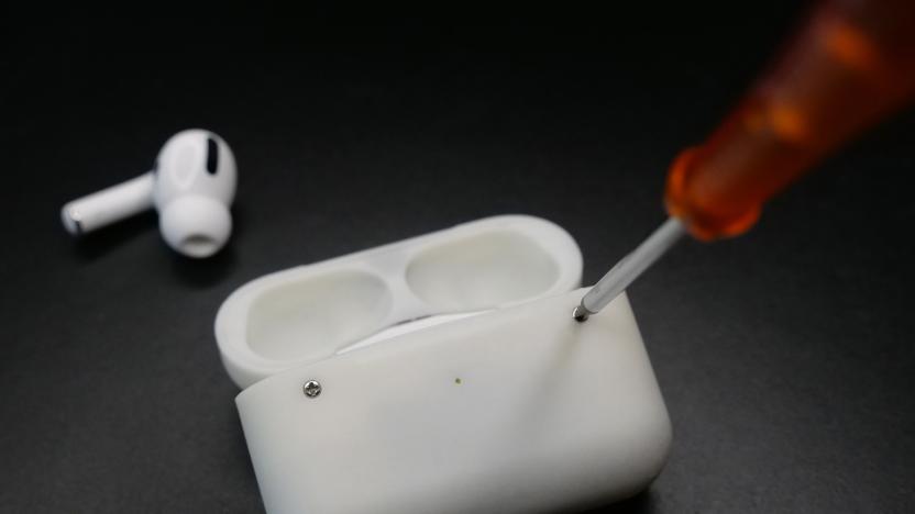 A custom AirPods Pro case with screws. A screwdriver is unscrewing one of the two visible screws. A lone AirPods Pro bud sits on the dark surface behind it.