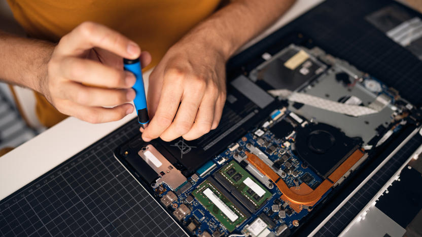 High angle view of unrecognizable Caucasian man with screwdriver repairing his laptop