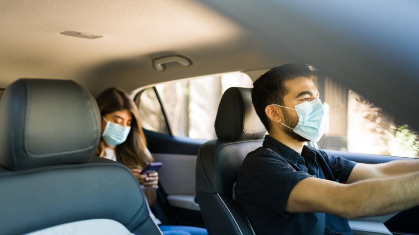 Handsome man driving a car and working as a rideshare driver during the coronavirus pandemic