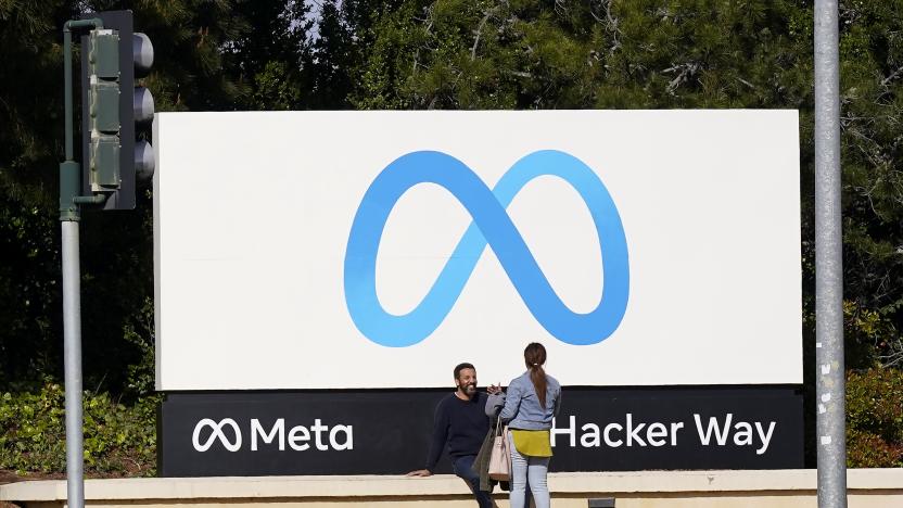 ARCHIVO - Un grupo de personas conversa junto a un cartel de Meta en el exterior de la sede de la empresa en Menlo Park, California, el 7 de marzo de 2023. (AP Foto/Jeff Chiu)