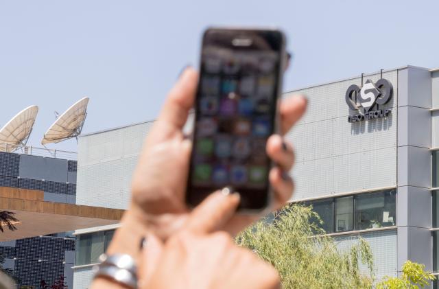 An Israeli woman uses her iPhone in front of the building housing the Israeli NSO group, on August 28, 2016, in Herzliya, near Tel Aviv. - Apple iPhone owners, earlier in the week, were urged to install a quickly released security update after a sophisticated attack on an Emirati dissident exposed vulnerabilities targeted by cyber arms dealers.
Lookout and Citizen Lab worked with Apple on an iOS patch to defend against what was called "Trident" because of its triad of attack methods, the researchers said in a joint blog post.
Trident is used in spyware referred to as Pegasus, which a Citizen Lab investigation showed was made by an Israel-based organization called NSO Group. (Photo by JACK GUEZ / AFP) (Photo by JACK GUEZ/AFP via Getty Images)
