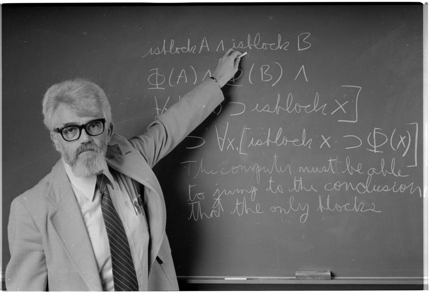 Prof. McCarthy explains the equation on the blackboard thus: "The computer must be able to jump to the conclusion that the only blocks on the table are the ones it knows about." The equation represents this process of extended logic, which is unfamiliar to most logicians.  (Photo by © Roger Ressmeyer/CORBIS/VCG via Getty Images)
