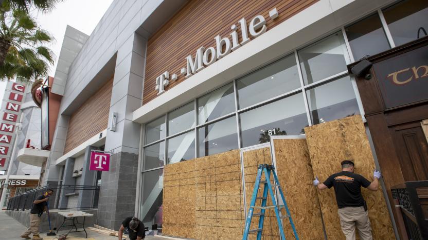 LONG BEACH, CA - JUNE 01:  After rioters looted, destroyed and burned businesses along Pine Ave. Sunday evening, workers replace broken glass at a T-Mobile store with plywood Monday, June 1, 2020 in Long Beach, CA.  (Allen J. Schaben / Los Angeles Times via Getty Images)