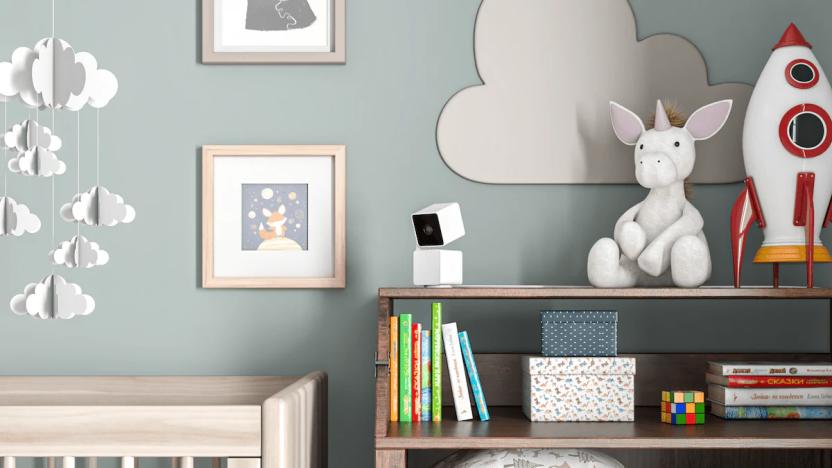 A security camera on top of a shelf in a room with baby blue walls and a crib.