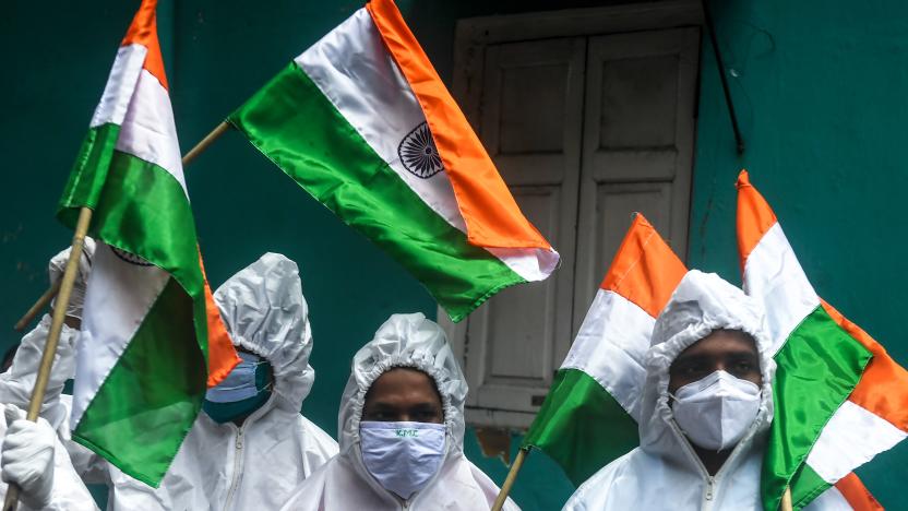 Frontline COVID-19 coronavirus warriors such as health workers, patients ambulance drivers, crematorium workers, wearing Personal Protective Equipment (PPE) suits hold Indian national flags as part of the Independence Day celebrations in Kolkata on August 15, 2020. - India's Prime Minister Narendra Modi issued a new warning to China over deadly border tensions on August 15, using his most important speech of the year to promise to build a stronger military. (Photo by Dibyangshu SARKAR / AFP) (Photo by DIBYANGSHU SARKAR/AFP via Getty Images)