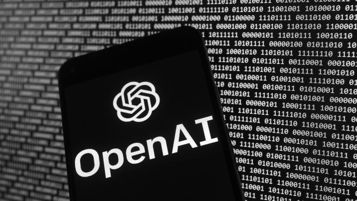 The OpenAI logo appears on a mobile phone in front of a computer screen with random binary data, Thursday, March 9, 2023, in Boston. (AP Photo/Michael Dwyer)