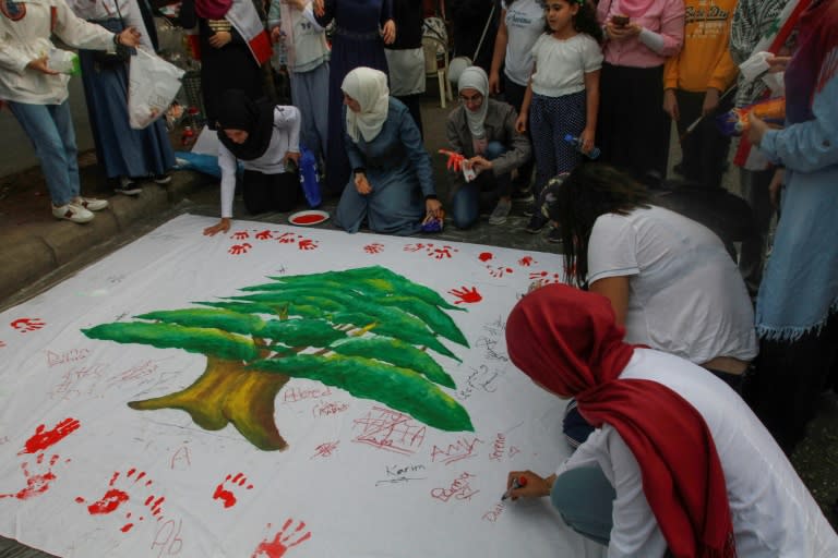 Lebanese citizens draw the national flag during a demonstration in the southern Lebanese city of Sidon -- a symbol of unity among protesters from across traditional sectarian divides (AFP Photo/Mahmoud ZAYYAT)