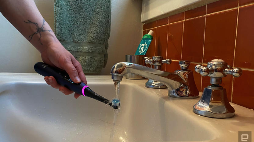 The Oral-B series 7 smart toothbrush under running water in a bathroom sink. 