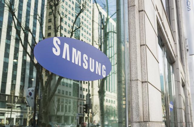 Seoul, Republic of Korea - March 26, 2013: The Samsung logo on the window of one of the South Korean company's offices in Gangnam, central Seoul, with cars and people on the street reflected  in the window.