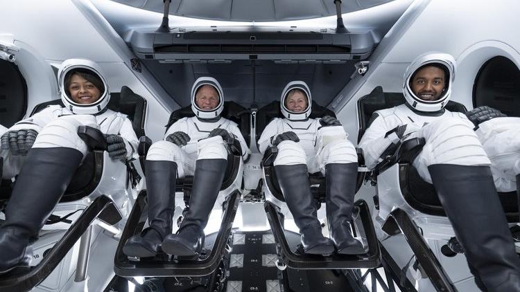 A group photo of the Axiom Mission 2 crew aboard a SpaceX Crew Dragon. From left to right, the astronauts are Rayyanah Barnawi, John Shoffner, Peggy Whitson and Ali Alqarni.