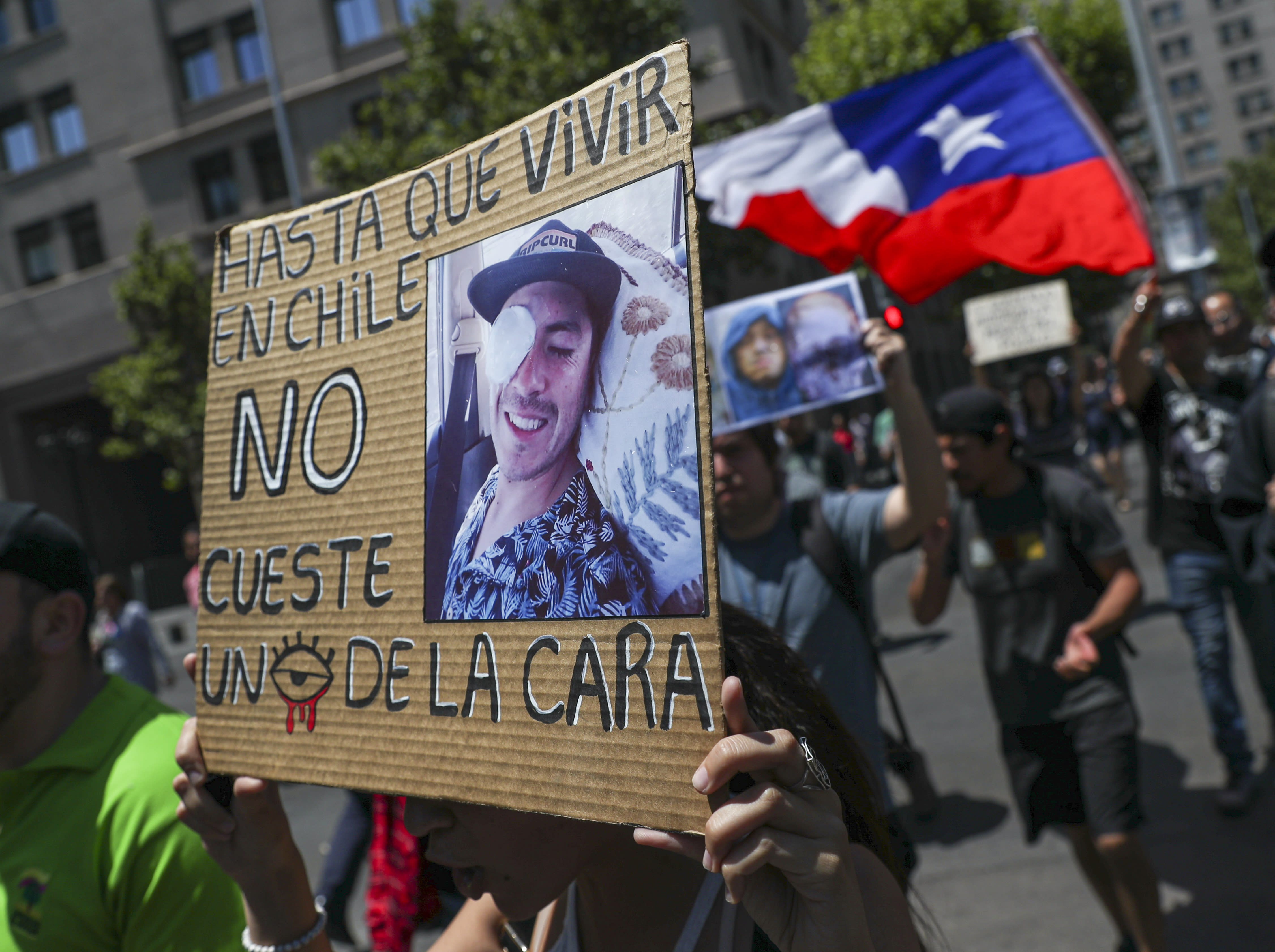 A woman holds a sign that reads in Spanish: 