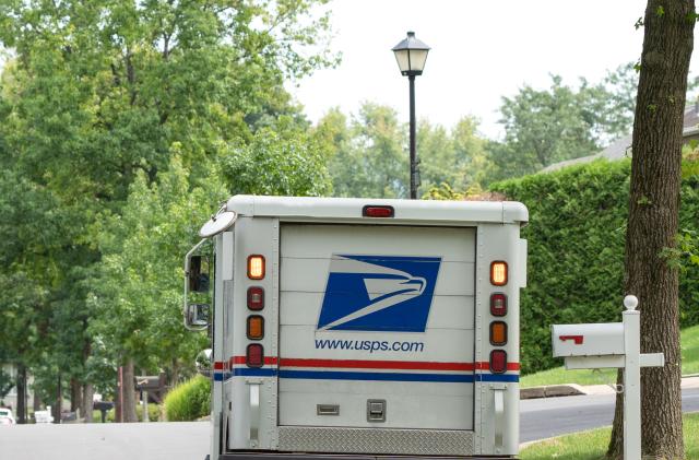 Berks County, Pennsylvania, USA-August 15, 2020: USPS truck delivering mail on suburban street in Pennsylvania.