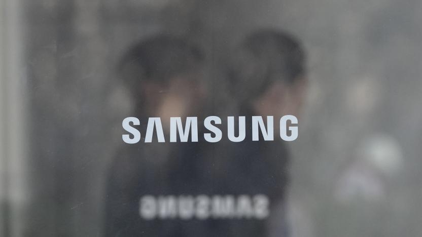 Employees walk past logos of the Samsung Electronics Co. at its office in Seoul, South Korea, Wednesday, Jan. 31, 2024. Samsung Electronics on Wednesday reported an annual 34% decline in operating profit for the last quarter as sluggish demands for its TVs and other consumer electronics products offset hard-won gains from a slowly recovering computer chip market. (AP Photo/Ahn Young-joon)