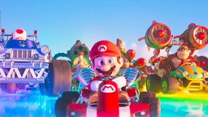 Mario races down a track with Toad and Donkey Kong behind him. 