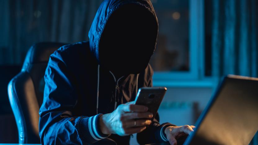 Anonymous hacker programmer uses a laptop to hack the system in the dark. Creation and infection of malicious virus. The concept of cybercrime and hacking database