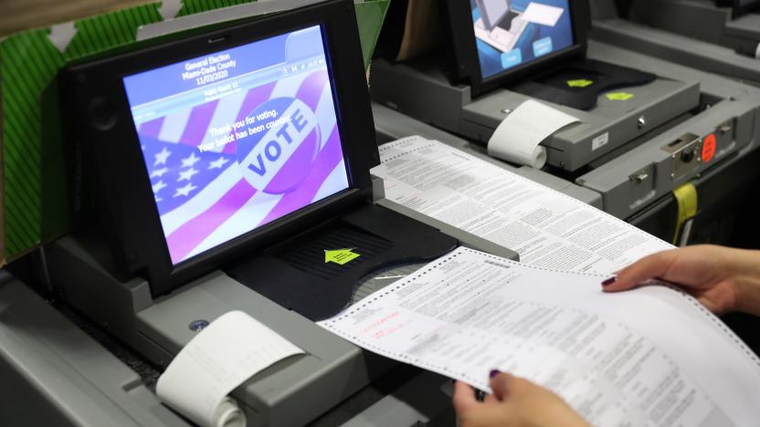 DORAL, FLORIDA - OCTOBER 14: A Miami-Dade election worker feeds ballots into a voting machines during an accuracy test at the Miami-Dade Election Department headquarters on October 14, 2020 in Doral, Florida. The test was done as the county prepares for the November 3rd election where President Donald Trump and Democratic presidential candidate Joe Biden are facing off against each other. (Photo by Joe Raedle/Getty Images)