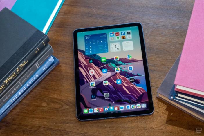 An iPad on a desk surrounded by books. 