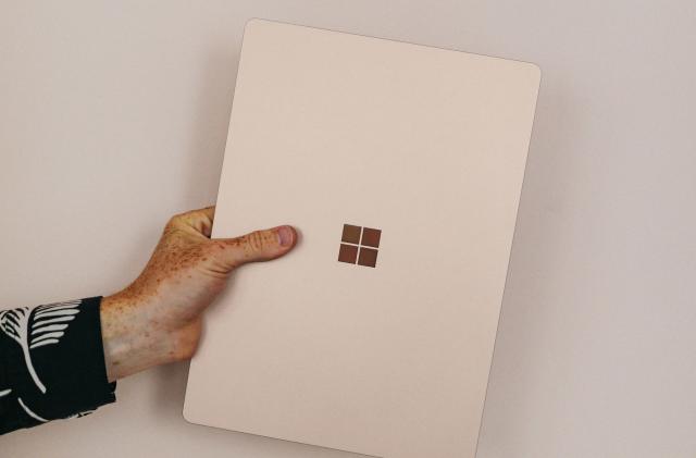 A hand holding a Microsoft device. 