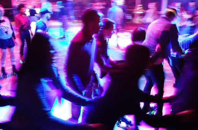 Blurred Motion Of People Enjoying At Roller Disco At Night