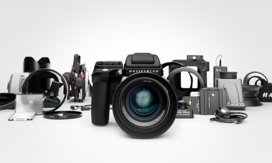 Hasselblad marketing photo showing the H6D DSLR in the center flanked by numerous accessories to its left and right.