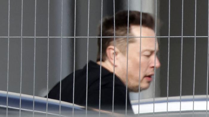 Tesla CEO Elon Musk arrives at the company's electric car plant in Gruenheide near Berlin, eastern Germany, on March 13, 2024, as employees resumed work after production had to be halted due to a suspected arson attack that caused a power outage. Damage to the lines knocked out power to the plant as well as cutting electricity to surrounding villages since power lines supplying the factory were set on fire in the early hours of March 5, 2024. Far-left activists from the "Vulkangruppe" (Volcano Group) have claimed responsibility for the sabotage, saying they aimed to achieve "the biggest possible blackout of the gigafactory", a reference to the Tesla plant. (Photo by Odd ANDERSEN / AFP) (Photo by ODD ANDERSEN/AFP via Getty Images)