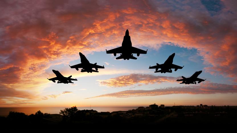 Five fighters flying at sunset