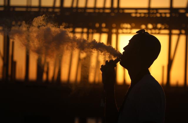 Young woman vaping as the national lockdown ends and the new three tier system of local coronavirus restrictions begins, shoppers head out to Oxford Street to catch up on shopping as non-essential shops are allowed to reopen on 2nd December 2020 in London, United Kingdom. Many shoppers wear face masks outside on the street as a precaution as there are so many people around. (photo by Mike Kemp/In Pictures via Getty Images)