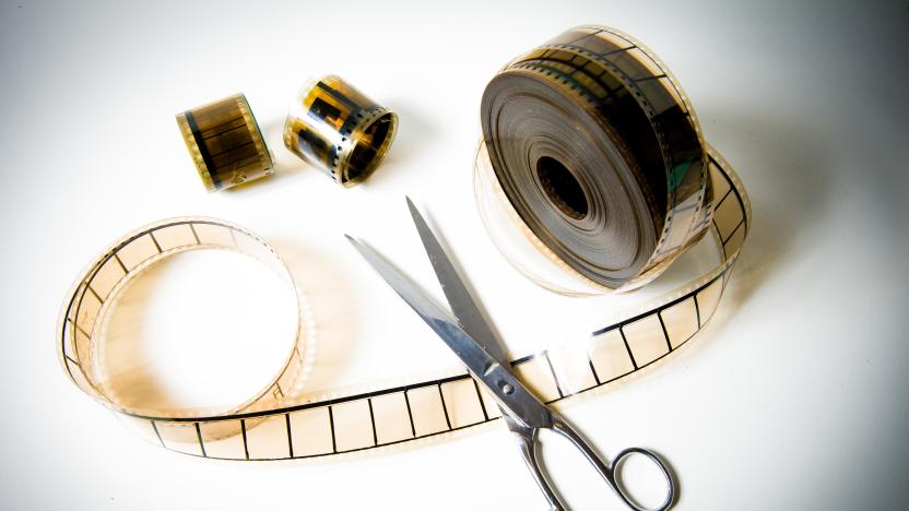 A 35mm movie film reel cutted with scissors on white background and color effect