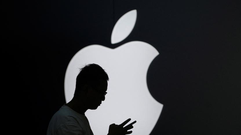 A man check his phone near an Apple logo outside its store in Shanghai, China September 13, 2023. REUTERS/Aly Song