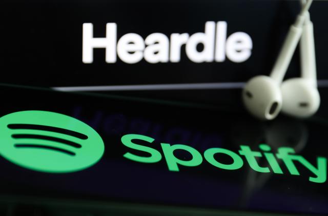 Heardle logo displayed on a laptop screen, Spotify logo displayed on a phone screen and headphones are seen in this illustration photo taken in Krakow, Poland on July 12, 2022. (Photo by Jakub Porzycki/NurPhoto via Getty Images)