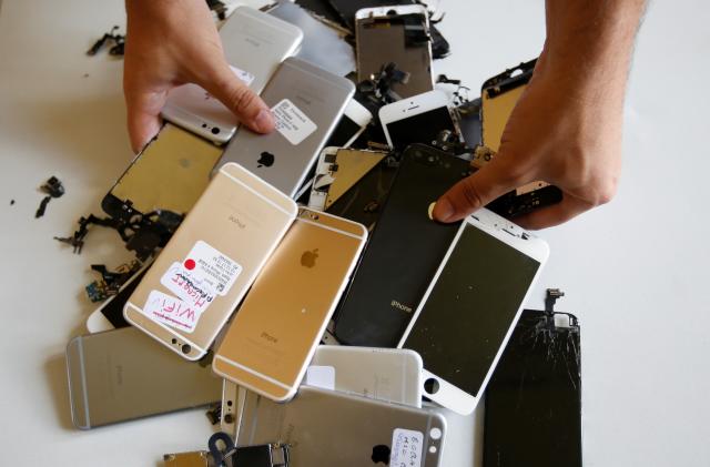 Worker checks Apple Iphones as he refurbishes cell phones at a workshop of the Oxflo company, specialised in refurbishment of broken European smartphones which will be resold back and provided with a warranty as part of an eco-responsible approach, in Lusignac, France, June 20, 2019. REUTERS/ Regis Duvignau