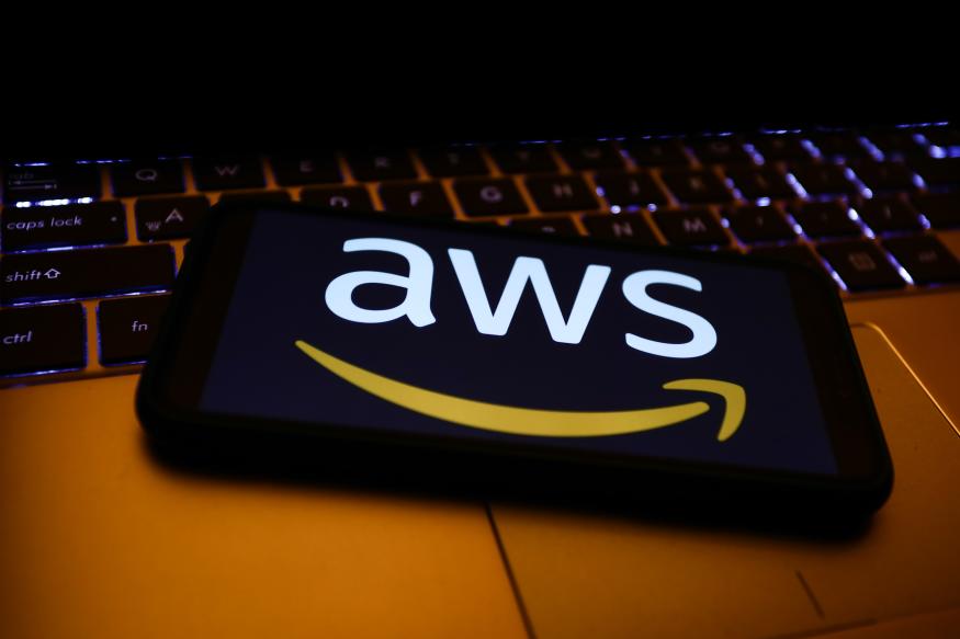 Amazon Web Services logo displayed on a phone screen and a laptop keyboard are seen in this illustration photo taken in Krakow, Poland on December 1, 2021. (Photo by Jakub Porzycki/NurPhoto via Getty Images)