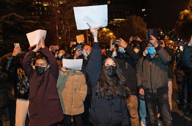 BEIJING, CHINA - NOVEMBER 27: Demonstrators hold white signs as a form of protest during a protest against Zero Covid and epidemic prevention restrictions in Beijing, China, on Sunday, November 27, 2022. (Photo by )