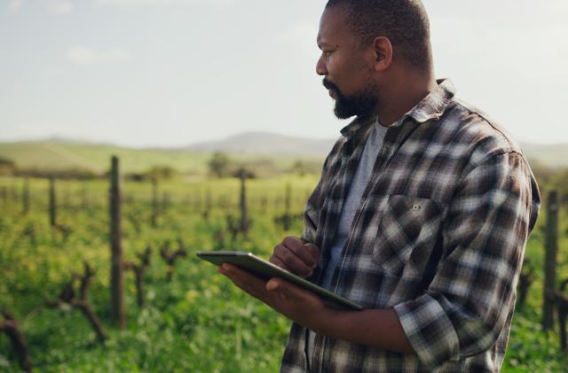 Shot of a mature man using a digital tablet while working on a farm