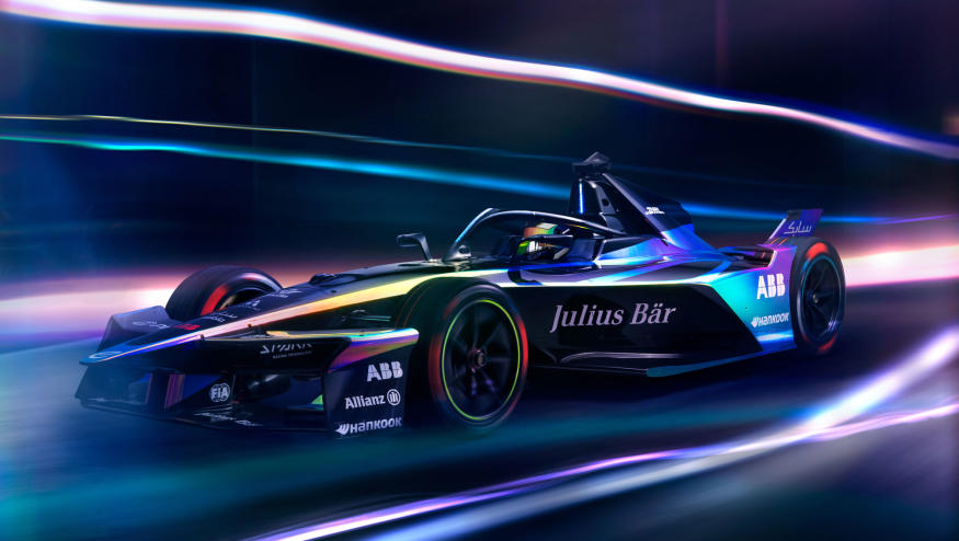 Formula E Gen3 Evo race car in motion with blurred lights all around it. 