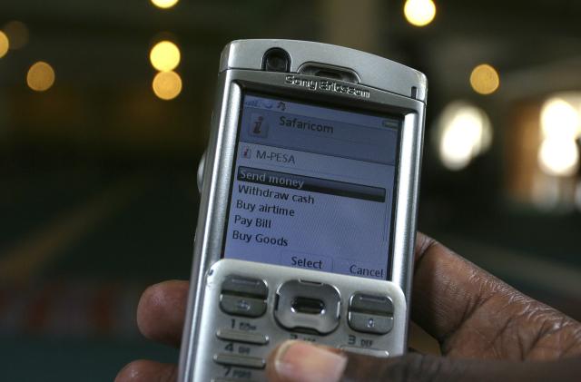 A man scrolls through his mobile phone to carry out a money transaction via M-PESA in Nairobi May 12, 2009. Teaming up with Kenya Commercial Bank to let phone users who do not have bank accounts send each other money, M-PESA, the virtual cash network, hit on a formula that has attracted 6.5 million customers, or one in six Kenyans, in just over two years. Picture taken May 12, 2009. To match feature AFRICA-PHONES/   REUTERS/Noor Khamis (KENYA BUSINESS SOCIETY)