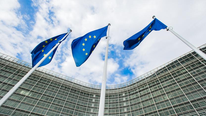 Steeples with blue flags of the European Union against the background of the European Commission building Berlaymont in Brussels, Belgium. EU flag, symbol